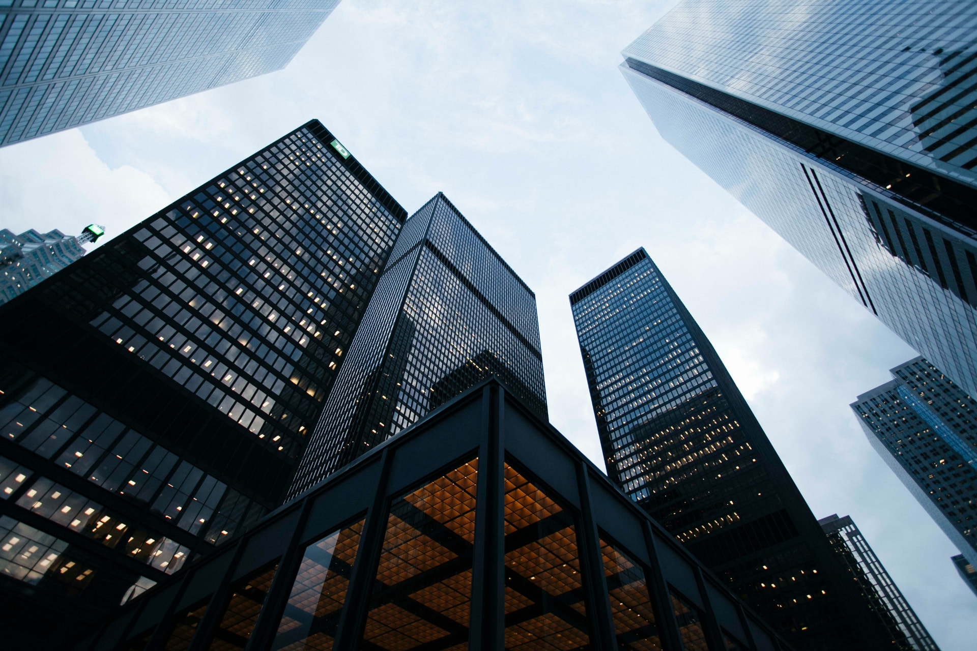 Corporate towers viewed from below against a bright sky
